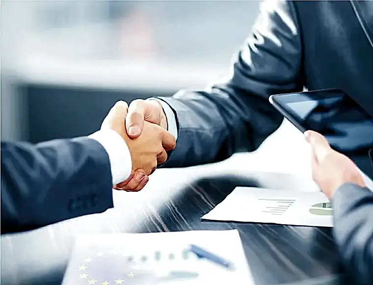 Two businessmen shaking hands as they finalize their transaction and secure Cyprus permanent residency.