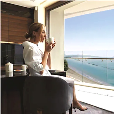 A woman enjoying her coffee in a luxurious apartment with a breathtaking sea view.