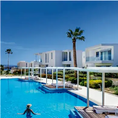 A swimming pool surrounded by luxurious properties, complemented by amazing weather on a sunny day.